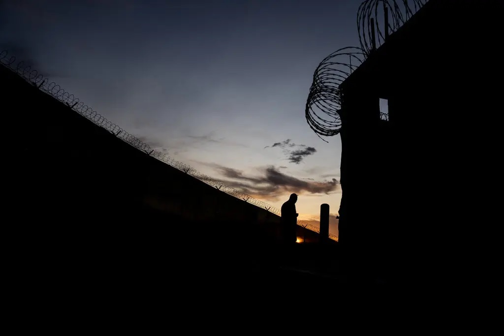 A silhouette of an individual against the sky with razor wire fencing at Guantnamo Bay Naval Base, Cuba.