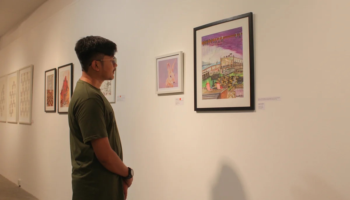 Saad Ahmed Rabbani looks at his fathers artwork at the IVS art gallery.  Photo by Hassaan Ahmed