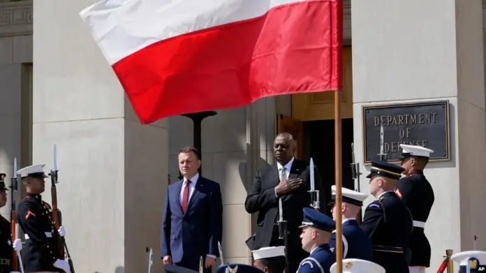 El secretario de Defensa, Lloyd Austin, a la derecha, junto al ministro de Defensa polaco, Mariusz Błaszczak, a la izquierda, mientras suena el himno nacional durante una ceremonia de llegada al Pentgono en Washington, el 20 de abril de 2022.