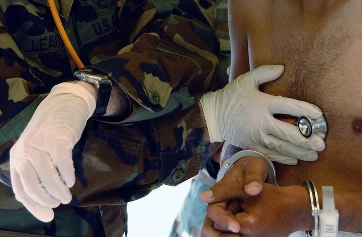 El teniente primero del ejrcito, Edwin Leavitt, verifica los latidos del corazn de un detenido recin llegado al Campamento X-Ray. Foto Suboficial de primera clase Shane T. McCoy/Marina de los EE. UU. va The New York Times.