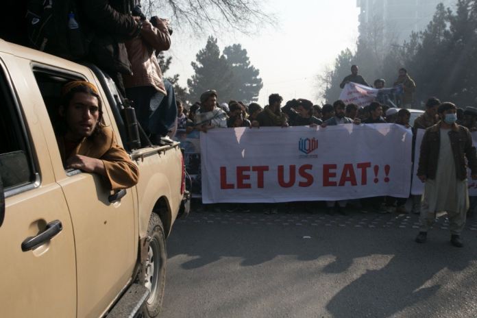 KABUL, AFGANISTN - 21 DE DICIEMBRE: Afganos con pancartas participan en una protesta y marchan hacia el antiguo edificio de la embajada de EE. UU. exigiendo la liberacin de los activos congelados de Afganistn y la reanudacin de los fondos internacionales en medio del empeoramiento de las condiciones econmicas y el aumento de la pobreza en el pas en Kabul, Afganistn el 21 de diciembre , 2021. Tras la toma de poder por parte de los talibanes, se detuvieron los fondos internacionales para Afganistn y se congelaron los activos del pas en el extranjero. (Foto de Bilal Guler/Agencia Anadolu a travs de Getty Images)