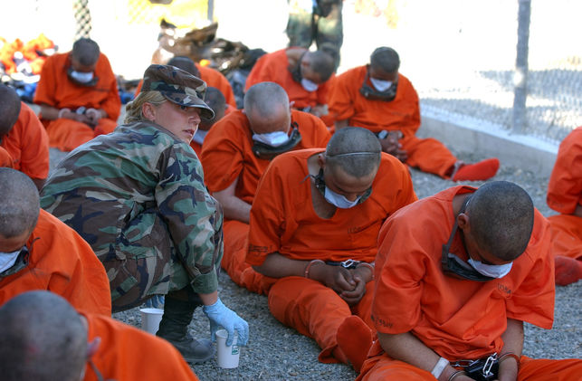 Una polica militar proporciona agua a los detenidos, febrero de 2002  US DoD